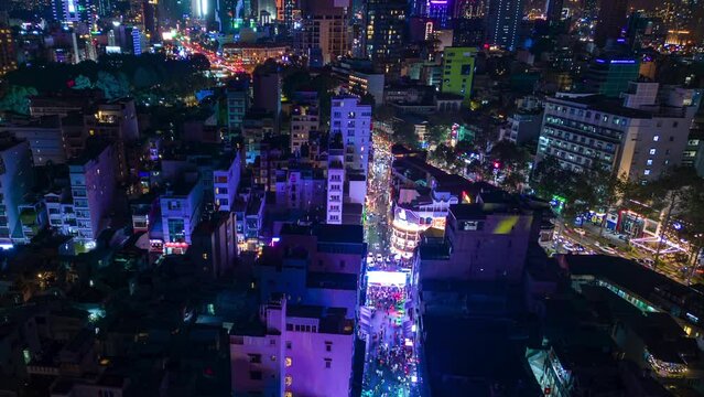 Night timelapse of downtown Ho Chi Minh City and the illuminated Bui Vien party street, Vietnam.