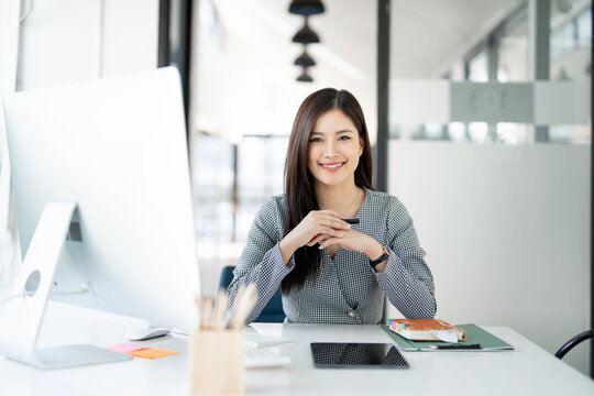 Image of young beautiful joyful woman smiling while working  in office