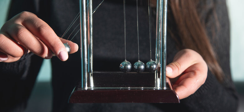Caucasian woman showing Newton's cradle balls.
