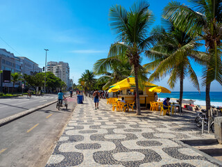 Ipanema beach with mosaic of sidewalk and kiosk in Rio de Janeiro, Brazil. Ipanema beach is the most famous beach of Rio de Janeiro, Brazil. Cityscape of Rio de Janeiro. - 772221875