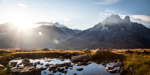 Panoramic view of the Drus mountains at sunrise with a lake at first plan