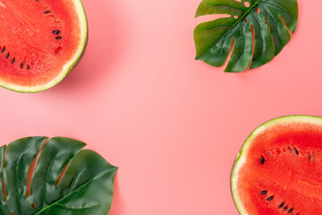 Watermelon with palm tree leaf on pink background. Creative minimal summer concept.