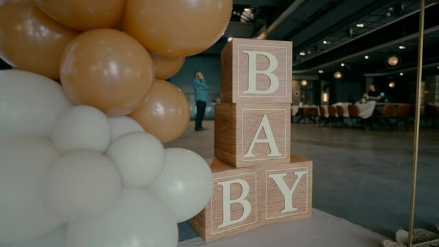 An event hall where circumcision is celebrated with balloons and bear dolls. Cubes with letters BABY.