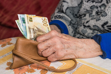 a small amount of Norwegian kroner in the hands of a pensioner, Financial concept, Problems of older people in Norway - 772236020
