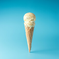 Ice cream scoop with ice cream cone on bright background. Minimal summer concept.