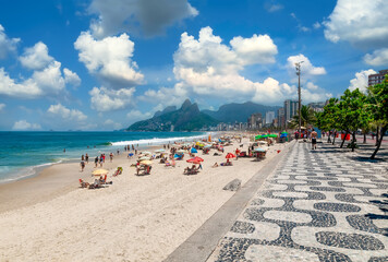 Ipanema beach with mosaic of sidewalk and mountain Dois Irmao (Two Brother)  in Rio de Janeiro, Brazil. Ipanema beach is the most famous beach of Rio de Janeiro, Brazil. Cityscape of Rio de Janeiro - 772238288