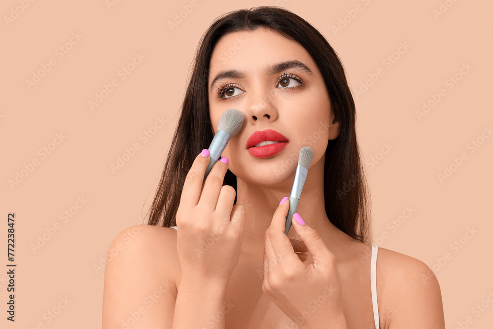 Sticker beautiful young woman with makeup brushes on beige background