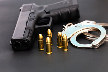 Hand gun with ammunition on dark background. 