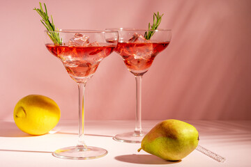 Refreshing cocktail in a glass with fruits on a bright background. Summer party concept.