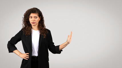 Skeptical businesswoman with hand gesture - obrazy, fototapety, plakaty