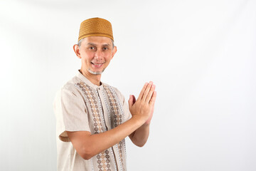 Portrait Asian Moslem Man with greetings and welcoming gestures, smiling face  © Tyas Indayanti