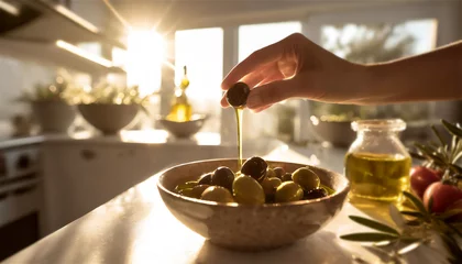 Fotobehang Kitchen scene with womans hand taking one black olive from a little bowl and some oil is running down © Rulan