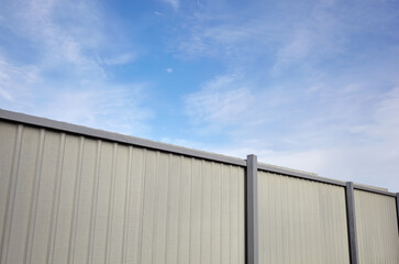 Corrugated steel fence against blue sky. Corrugated metal texture surface or galvanize steel