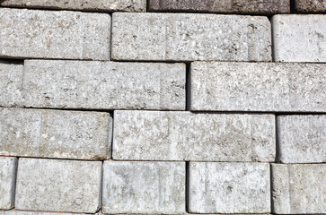 A closeup of a pile of stacked gray sand-lime bricks for building a house. Gray sand-lime brick