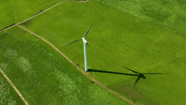 Cinematic view of white rotating windmill blades generating renewable energy