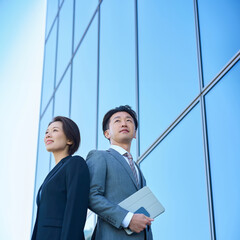スーツ姿の男女と現代的な建築
