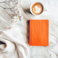 Coffee Cup and Orange Book on Marble Surface
