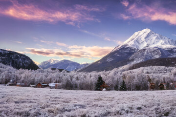 Fototapeta na wymiar Majestic snow-capped peaks pierce a clear winter sky in this stunning alpine landscape