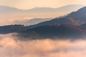 Obraz premium Beautiful view of the hills hidden in fog at sunset. Banska Bystrica, Slovakia.