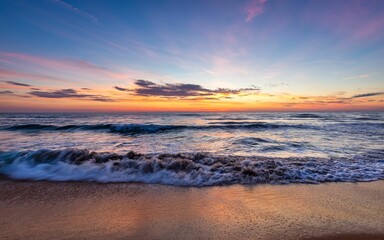Tranquil beachscape featuring a golden sunset over the ocean