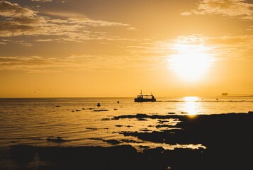 Fototapeta na wymiar Fishing boat silhouette against sunrise sky in Isle of Wight UK