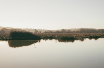 Misty still body of water in Brading marshes landscape view