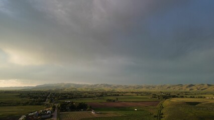 Aerial view of an arid farmland landscape under a cloudy sky. © Wirestock