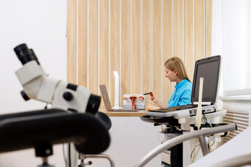 A gynecologist talks via video conference with a patient on a laptop in a modern hospital. Concept of professional medical online consultation, reproductive system and pregnancy.