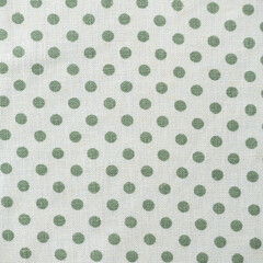White polka dot fabric as background, closeup of photo.