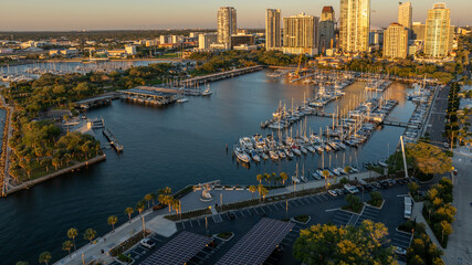 Golden sunrise illuminates downtown Saint Petersburg, Florida, highlighting boats at the yacht club, waterfront park, and cityscape.