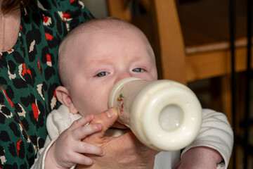 bébé en train de boire son biberon de lait