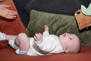 bébé heureux sur un canapé, regard, rire et émotions