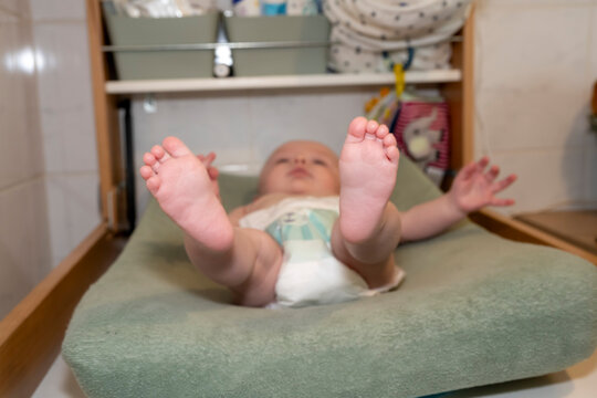 vue sur les pieds d'un bébé sur une table à langer avec une couche culotte