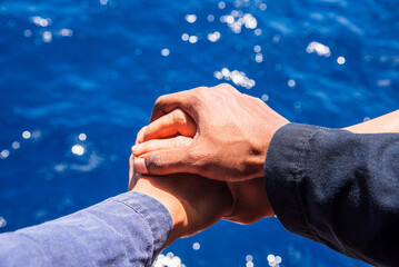 Close up top view of young seafarers putting their hands together. Friends with stack of hands...