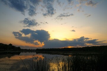 the sun setting in the distance with some clouds on it