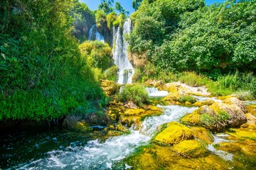 Majestic Kravica Waterfall cascading down amidst lush greenery and trees in Bosnia and Herzegovina