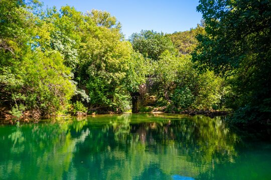 Tranquil scene of a lake surrounded by greenery near the Kravica Waterfall in Bosnia and Herzegovina