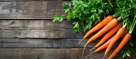 A bunch of vibrant organic carrots and parsley sitting on top of a rustic wooden table. - obrazy, fototapety, plakaty