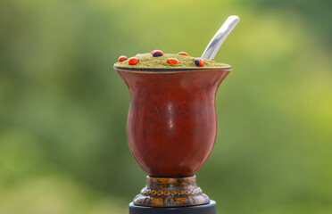 Chimarrão with Easter decoration. Yerba mate Ilex Paraguariensis. Colorful seeds of Ormosia...