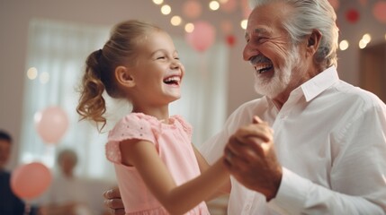 Close-up of a happy Gray-haired grandfather holding hands, dancing with his beloved granddaughter in the living room of the house. Family, Care, Holiday, Birthday, Celebration, Party concepts - obrazy, fototapety, plakaty