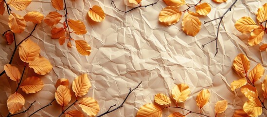 Close-up of crumpled craft paper covered with vibrant yellow autumn leaves.