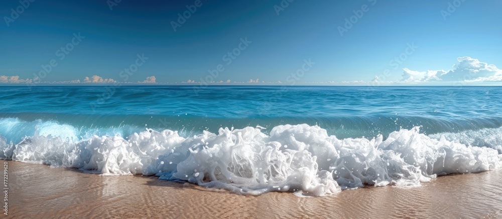 Poster a powerful ocean wave with white foam is rolling in on a sandy beach, creating a dynamic scene.