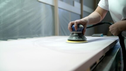 Sanding MDF panels using a machine, furniture production. The process of sanding a wooden panel,...