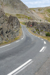 An empty winding road at the coast of Barents Sea in a rocky landscape, Finnmark Norway