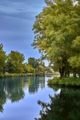 Tranquil scene of a tranquil body of water, reflecting the trees and sky.