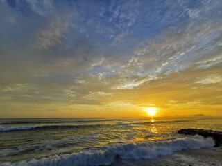 Fototapeta na wymiar Beautiful sunrise illuminating ocean waves.