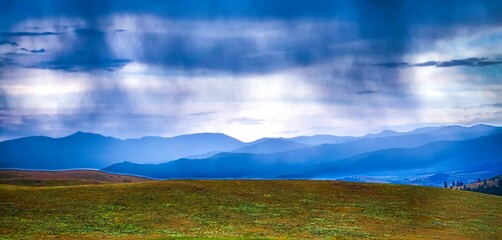 Stunning landscape of a pristine mountain range, with a lush green grassy field