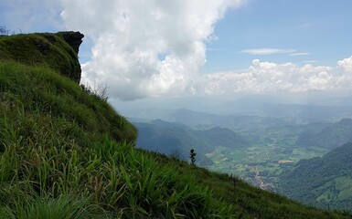Aerial view of a green mountain range under a cloudy sky