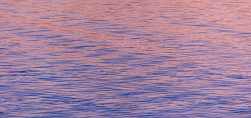 Majestic pink sunset over a tranquil body of water.