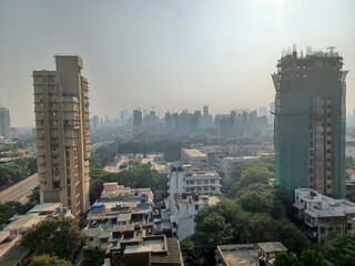 Mumbai, India - 10 March 2024: Rural to urban development of mumbai in sion west with trees and...